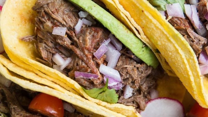 Instant Pot Shredded Beef Tacos with avocado, red onion and salsa. An amazingly flavorful, easy taco recipe!