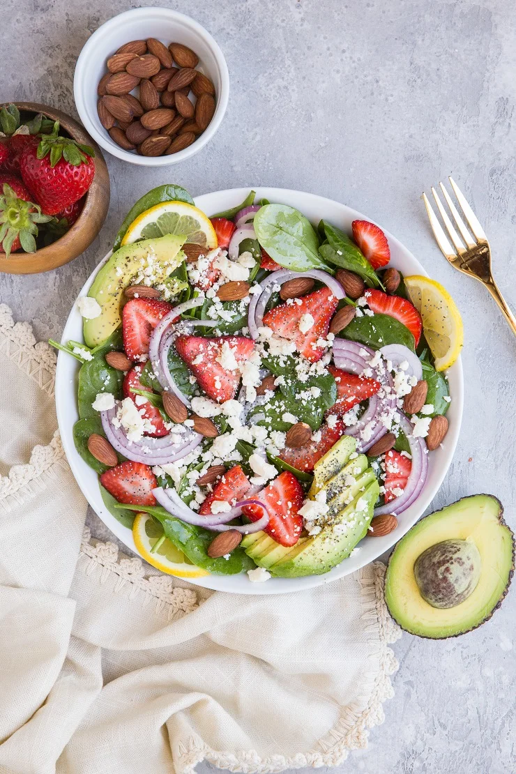 Strawberry Spinach Salad with Poppy Seed Dressing, avocado, roasted almonds, feta, and red onion! A beautiful, delicious salad recipe for any gathering!