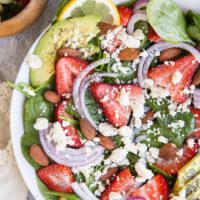 Strawberry Spinach Salad with Poppy Seed Dressing, avocado, roasted almonds, feta, and red onion! A beautiful, delicious salad recipe for any gathering! Amazing side dish or main entrée.