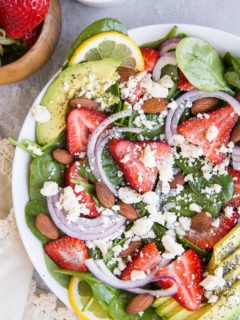 Strawberry Spinach Salad with Poppy Seed Dressing, avocado, roasted almonds, feta, and red onion! A beautiful, delicious salad recipe for any gathering! Amazing side dish or main entrée.