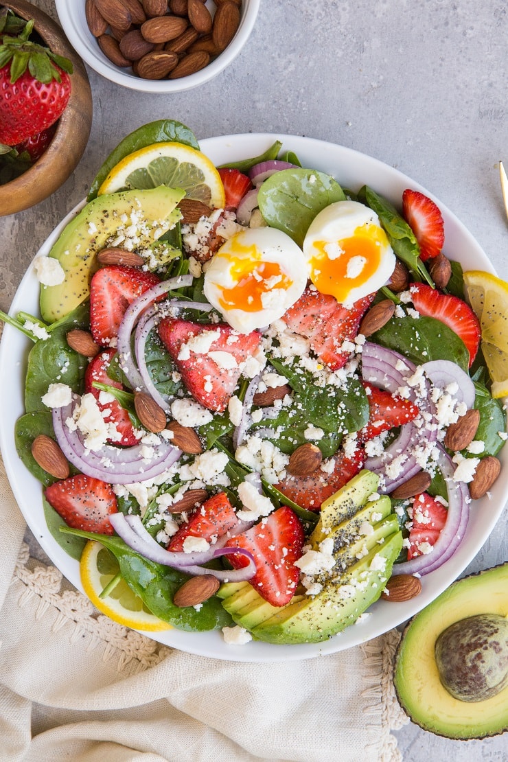 Strawberry Spinach Salad with Poppy Seed Dressing, avocado, roasted almonds, feta, and red onion! A beautiful, delicious salad recipe for any gathering! Amazing side dish or main entrée. Just add chicken!