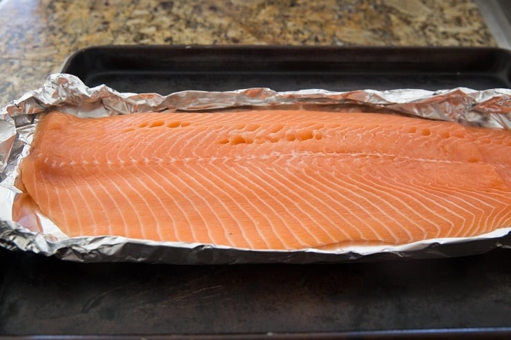 large salmon fillet on foil on a baking sheet