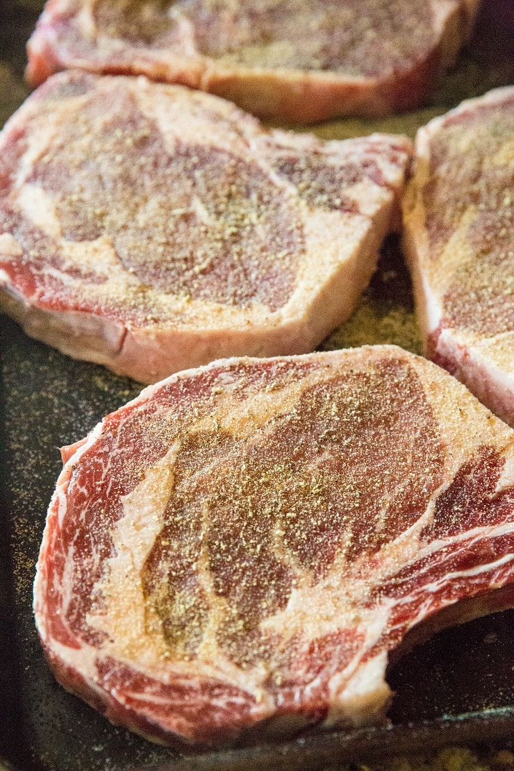 Bone-in ribeye steak seasoned with salt, garlic powder, and black pepper