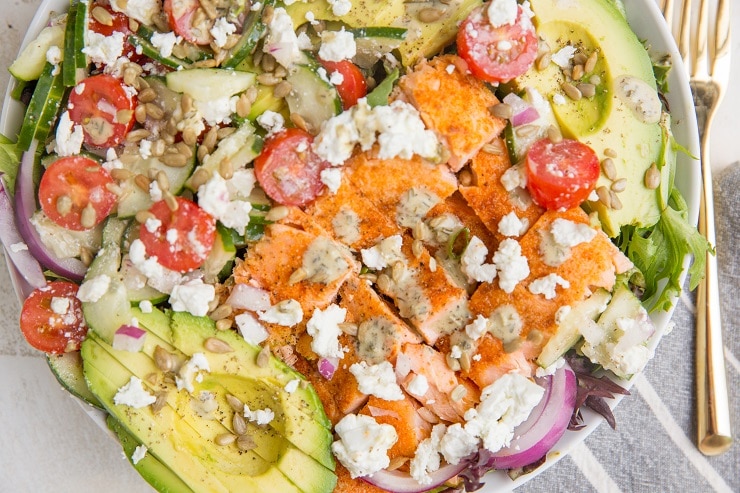 Greek Salmon Salad with feta, avocado, cucumber, tomatoes, red onion, and an herby dressing. This healthy satisfying salad recipe. Low-carb, keto and delicious for summer