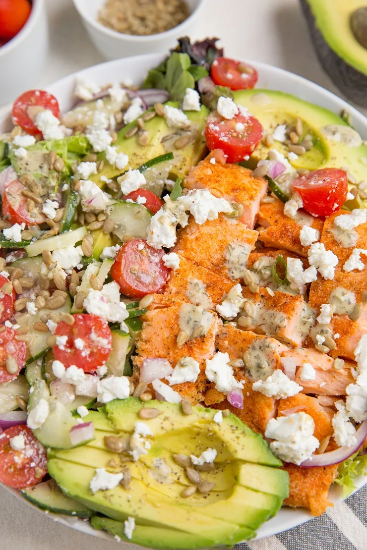 Greek Salmon Salad with Avocado, feta, cucumbers, tomatoes, red onion, and an herby dressing.