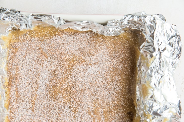 Cookie dough in a cake pan with cinnamon and sugar on top