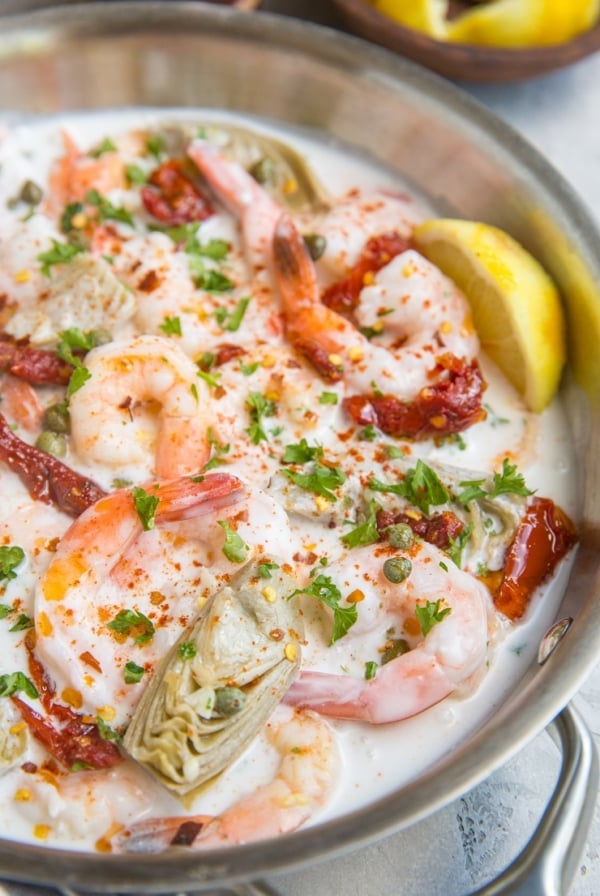 Creamy Tuscan Shrimp Recipe with sun-dried tomatoes, artichoke hearts, and more! Dairy-free, paleo, whole30, keto and delicious!
