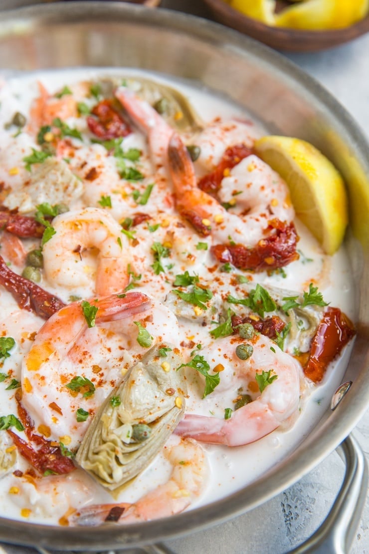 Creamy Tuscan Shrimp Recipe with sun-dried tomatoes, artichoke hearts, and more! Dairy-free, paleo, whole30, keto and delicious!