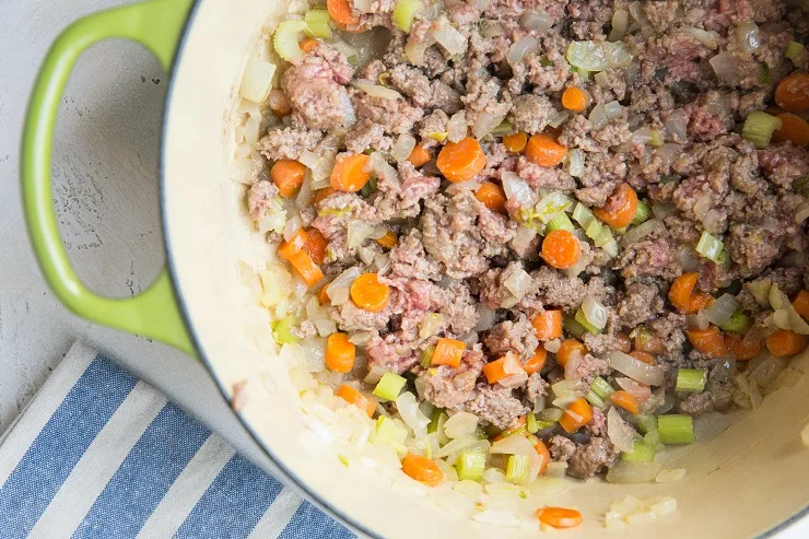 vegetables and ground beef cooking in a pot