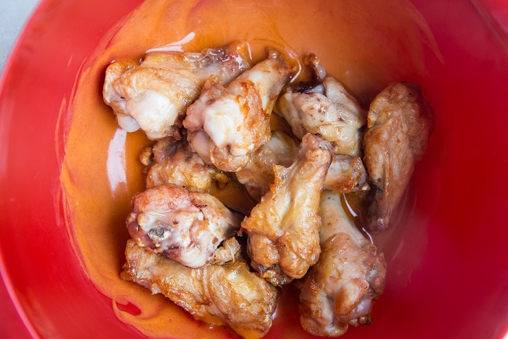 Put the cooked chicken in the bowl with the buffalo sauce.