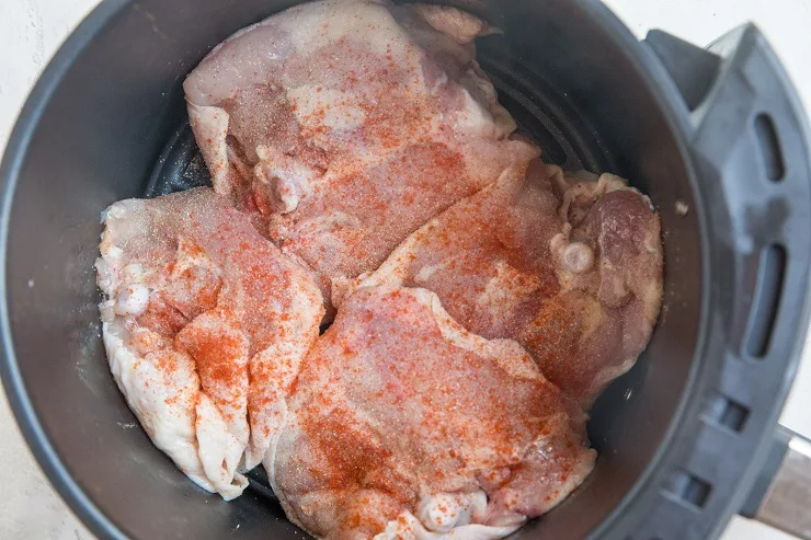 Place chicken thighs in air fryer skin-side down