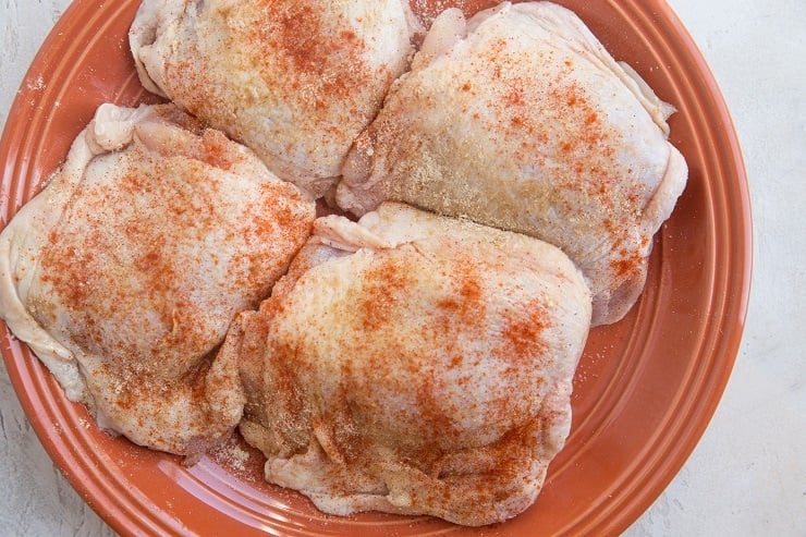 Drizzle the chicken thighs with oil and sprinkle with seasoning