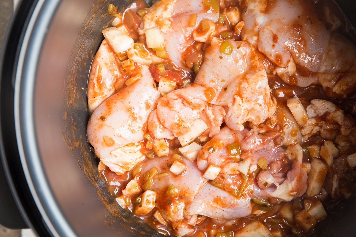 All of the ingredients for the shredded chicken stirred up in an instant pot, ready to pressure cook.