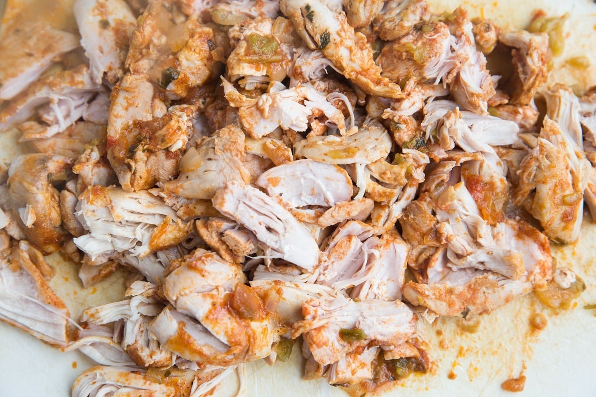 Shredded chicken on a cutting board.