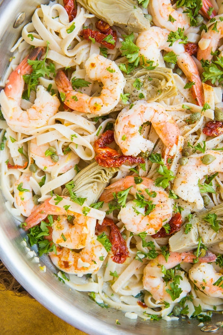 Mediterranean Shrimp Pasta with sun-dried tomatoes, artichoke hearts, capers, and lemon garlic cream sauce made gluten-free and dairy-free! A light and healthy pasta recipe!