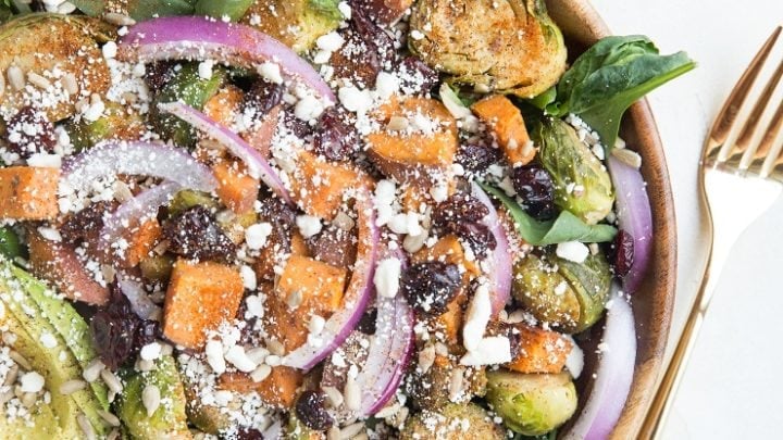 Nutritious superfood Roasted Sweet Potato and Brussel Sprouts Salad with cinnamon balsamic vinaigrette, avocado, dried cranberries, avocado, and more