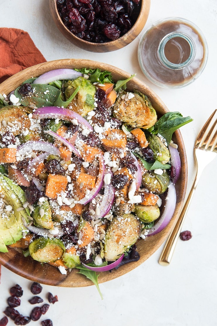 Nutritious superfood Roasted Sweet Potato and Brussel Sprouts Salad with cinnamon balsamic vinaigrette, avocado, dried cranberries, avocado, and more