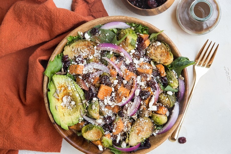 Fall salad recipe with roasted brussels sprouts and sweet potatoes, dried cranberries, feta, avocado, and cinnamon balsamic vinaigrette. A healthy vegetarian salad recipe