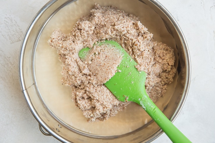 Transfer the crust mixture to a parchment-lined spring form pan.