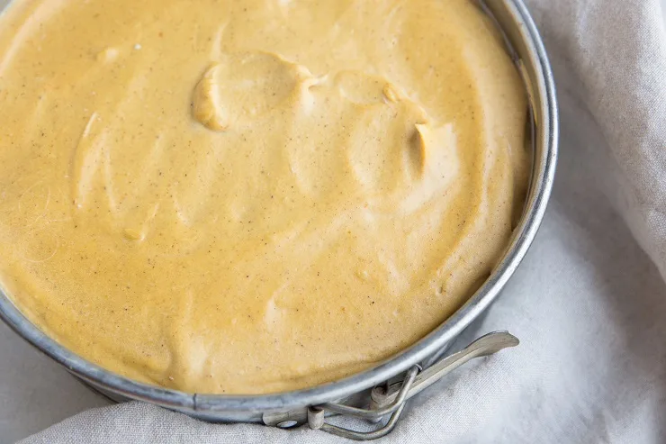 Spread the pumpkin cheesecake filling into an even layer over the crust