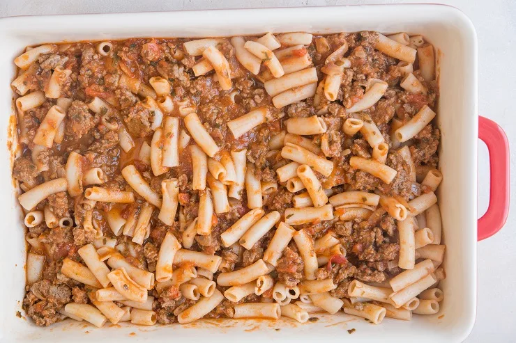 Combine the penne noodles and red meat sauce together in a casserole dish