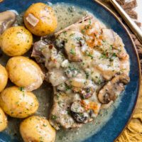 Slow Cooker Pork Chops with creamy garlic sauce, potatoes, and mushrooms