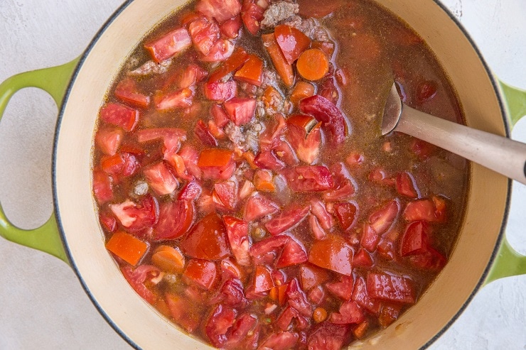 Stir in the chicken broth and tomatoes