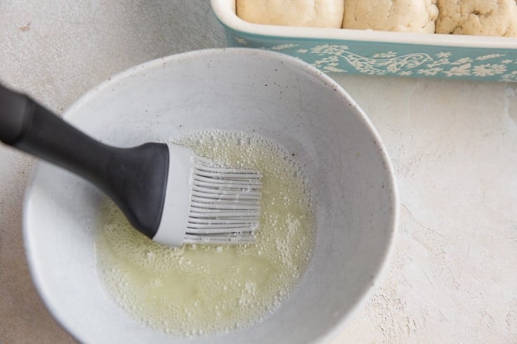 Whisk an egg white with water in a bowl for an egg wash