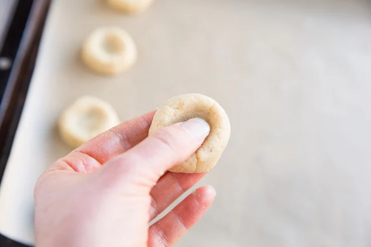 Roll the dough into a ball, then press the center with your thumb to make an indentation.