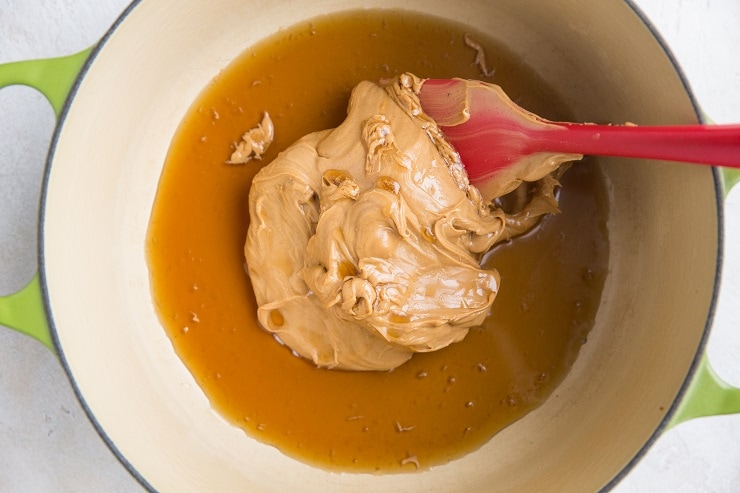 Stir together the peanut butter and maple syrup in a saucepan until melted and combined
