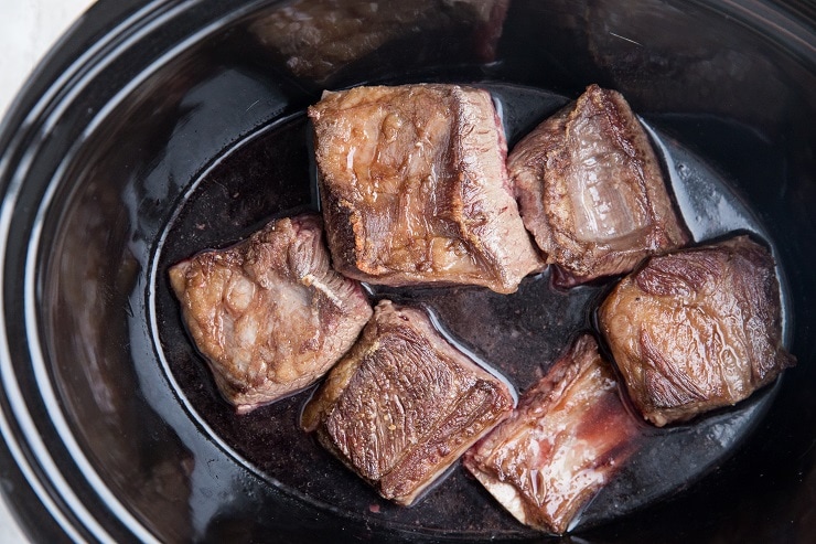 Transfer the chicken broth, cherry juice, and seared short ribs to the slow cooker