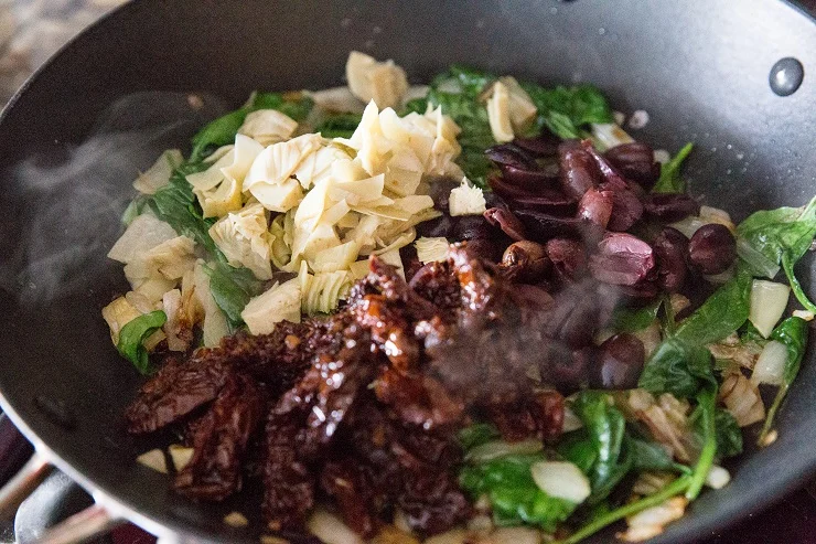 Add the kalamata olives, sun-dried tomatoes, artichoke hearts and spinach and stir well until spinach has wilted.