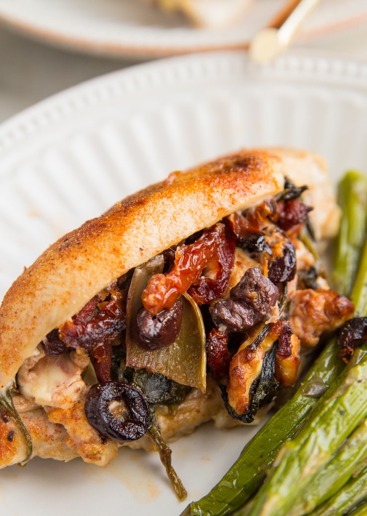 Mediterranean Stuffed Chicken with sun-dried tomatoes, artichoke hearts, feta, olives, spinach, and onion. A healthy, flavorful weeknight dinner recipe