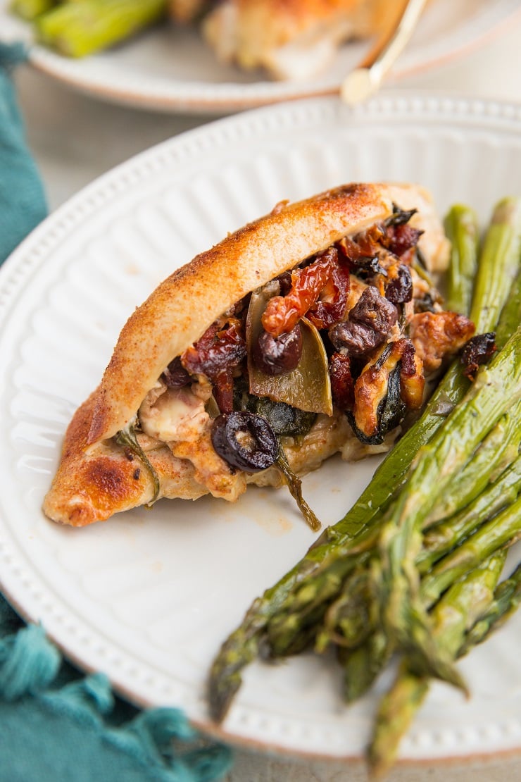 Mediterranean Stuffed Chicken with feta cheese, sun-dried tomatoes, kalamata olives, artichoke hearts, onion, and spinach. An easy, flavorful low-carb dinner recipe!