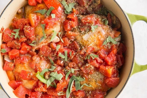 Dutch oven with chicken cacciatore ingredients inside, ready to cook