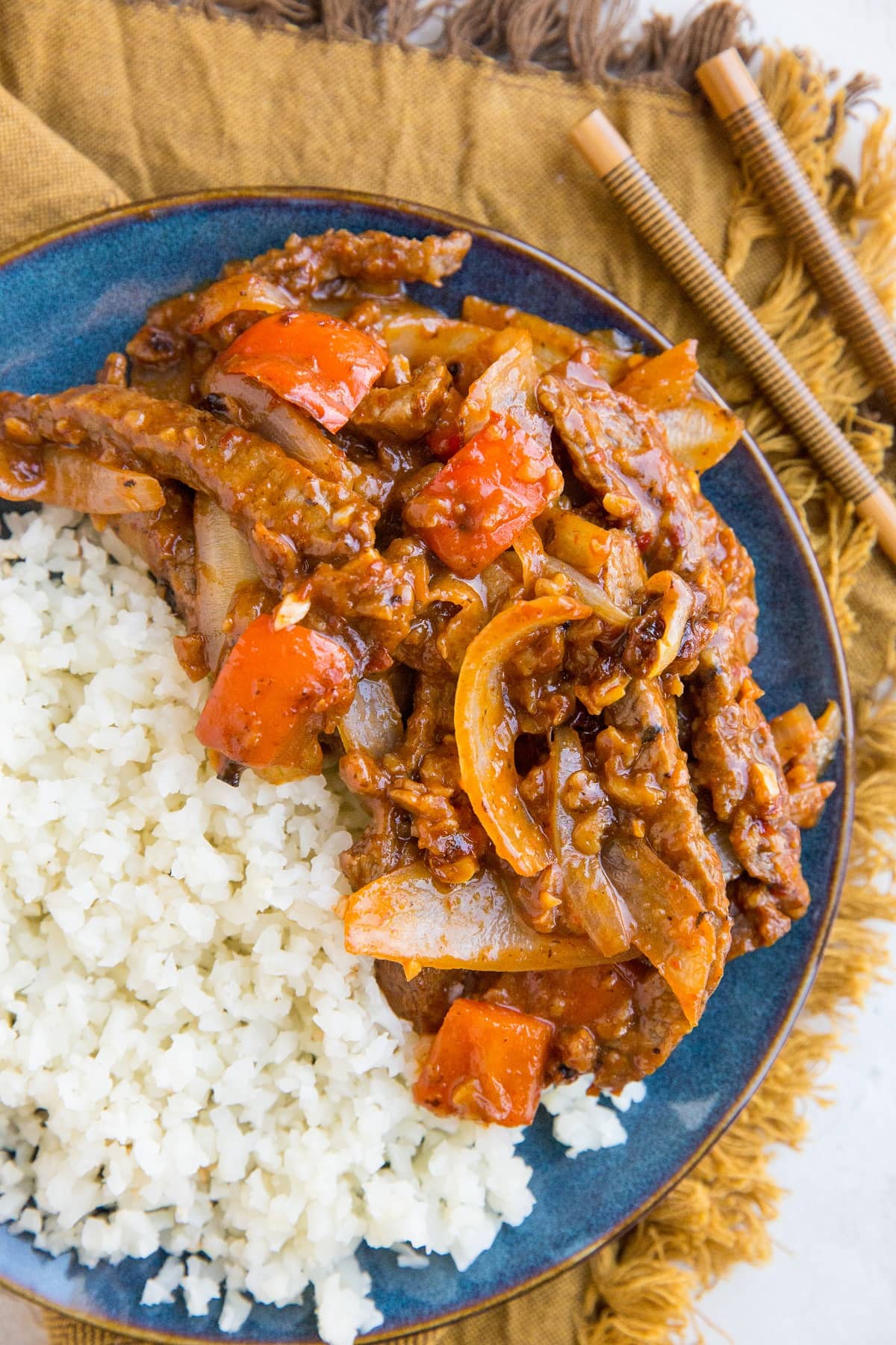 Blue plate of healthy Beijing Beef with a side of cauliflower rice