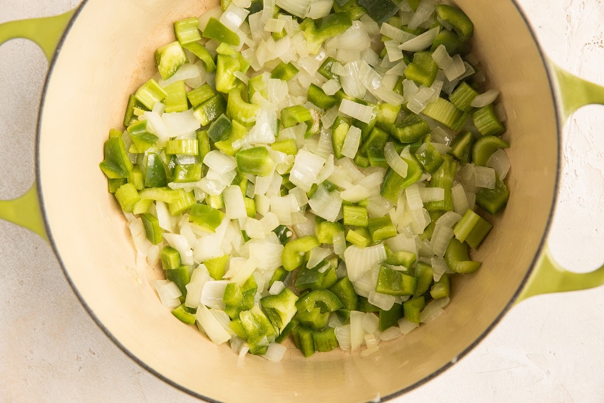 Onion, garlic and green bell pepper sautéing in a Dutch oven