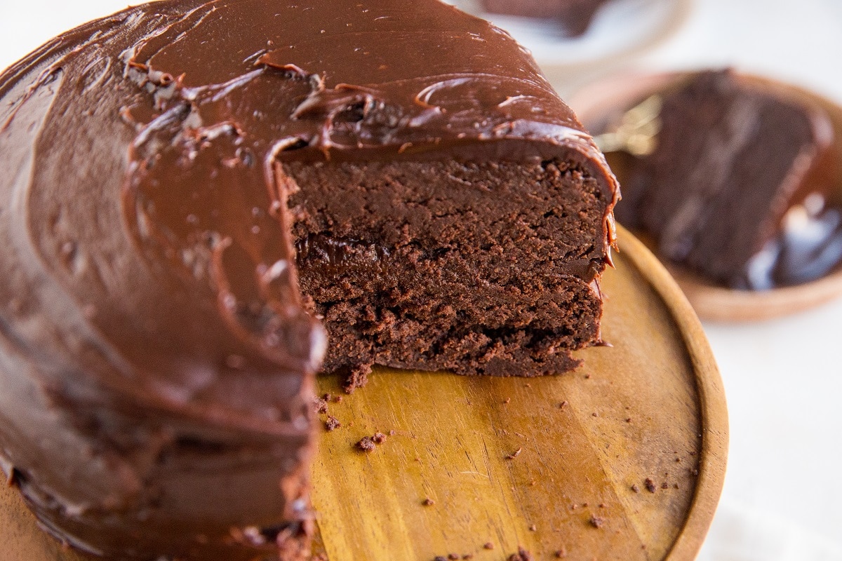 Brownie cake on a cake stand with slices taken out