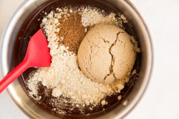 Almond flour, sugar-free sweetener, instant coffee granules and sea salt being mixed in to the melted chocolate