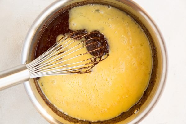 Saucepan with whisked egg and chocolate brownie batter