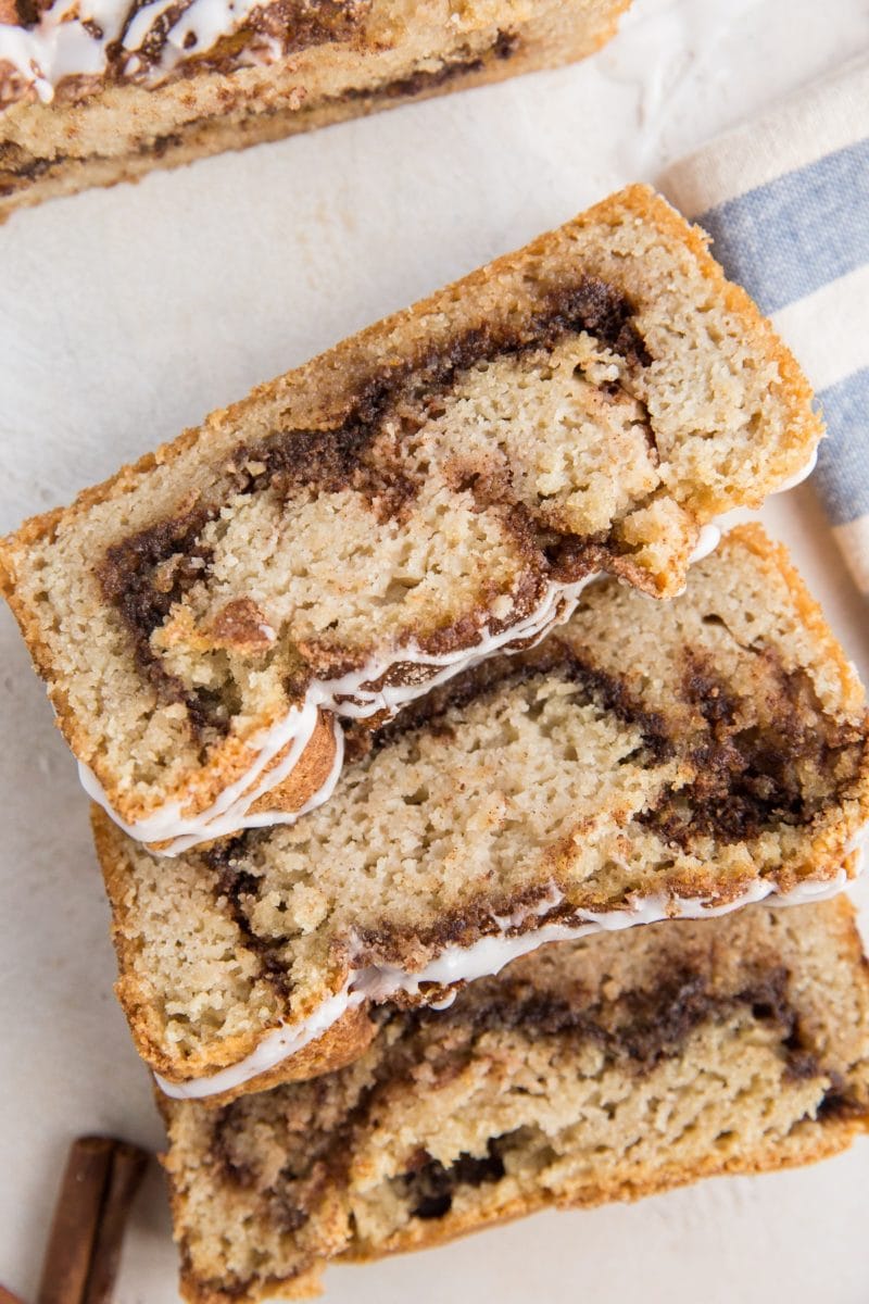 Top down photo of keto cinnamon swirl bread with three slices laying on top of each other and a blue striped napkin