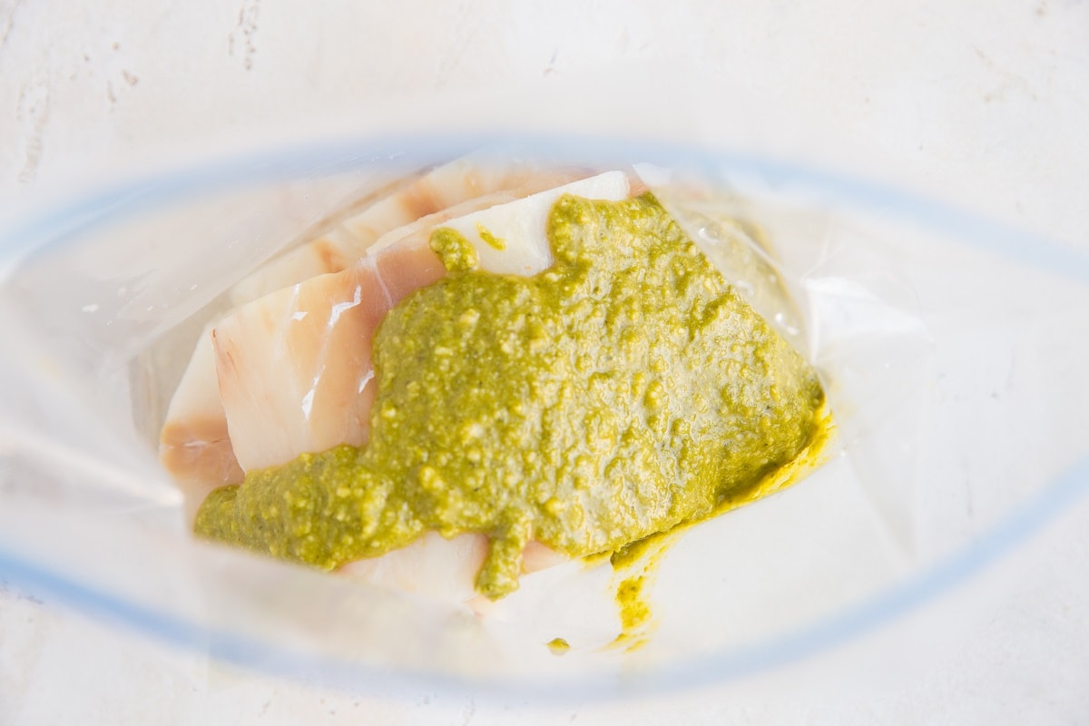 Add the cod and pesto sauce to a zip
