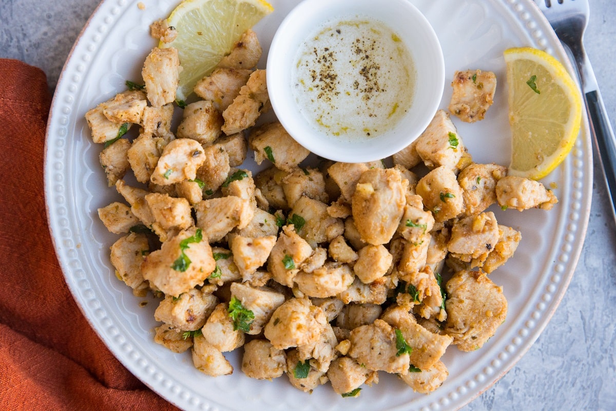 Serve lemon garlic chicken bites with melted butter as an appetizer.