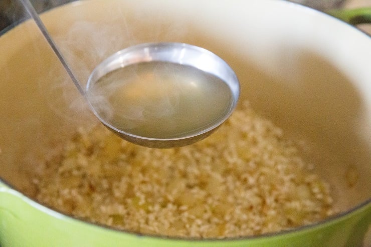 Stir in the chicken broth one ladle full at a time.