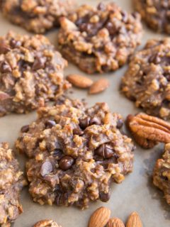 Baking sheet with nutty banana cookies with raw almonds and pecans next to the cookies