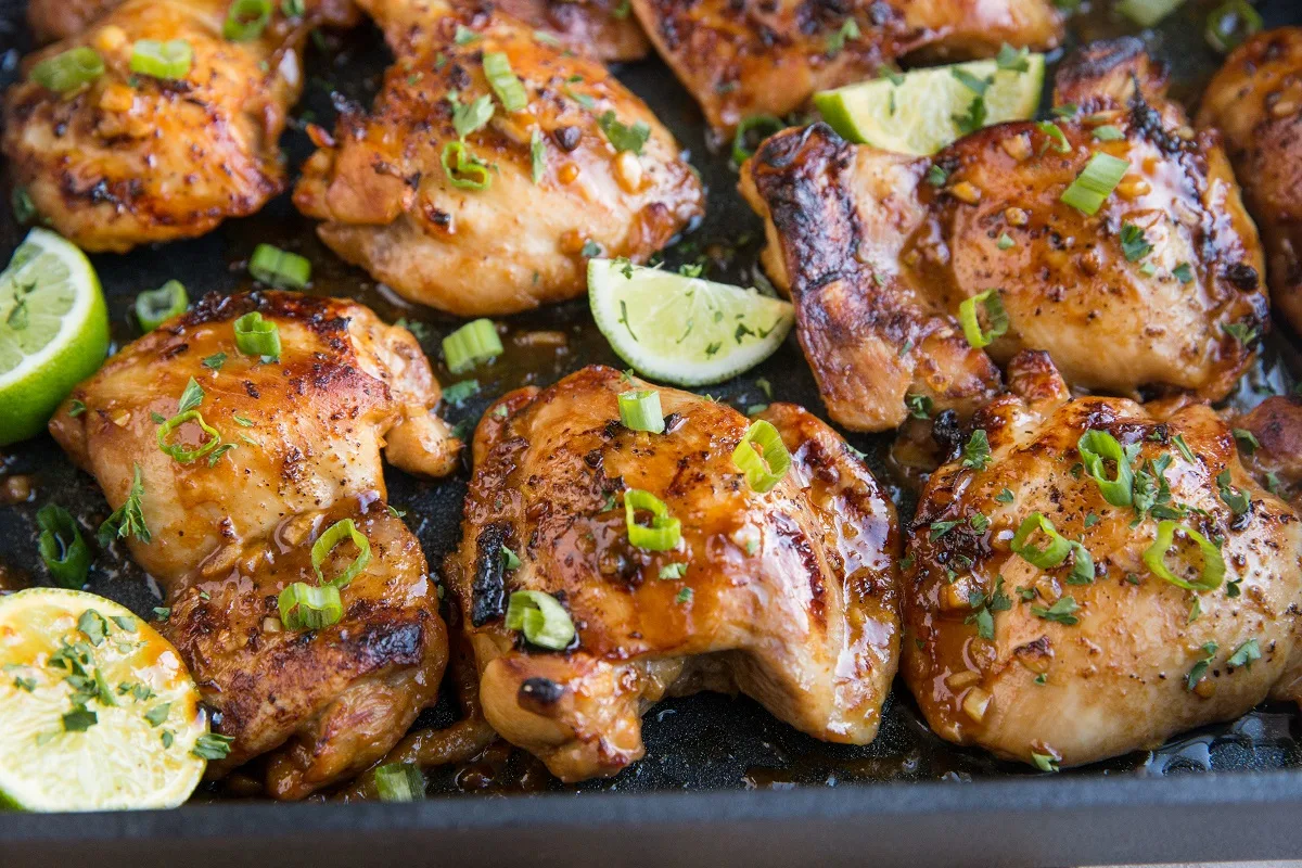 Horizontal photo of Asian baked chicken thighs in a black casserole dish