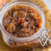 Jar full of freshly made bacon jam on top of a golden-brown napkin