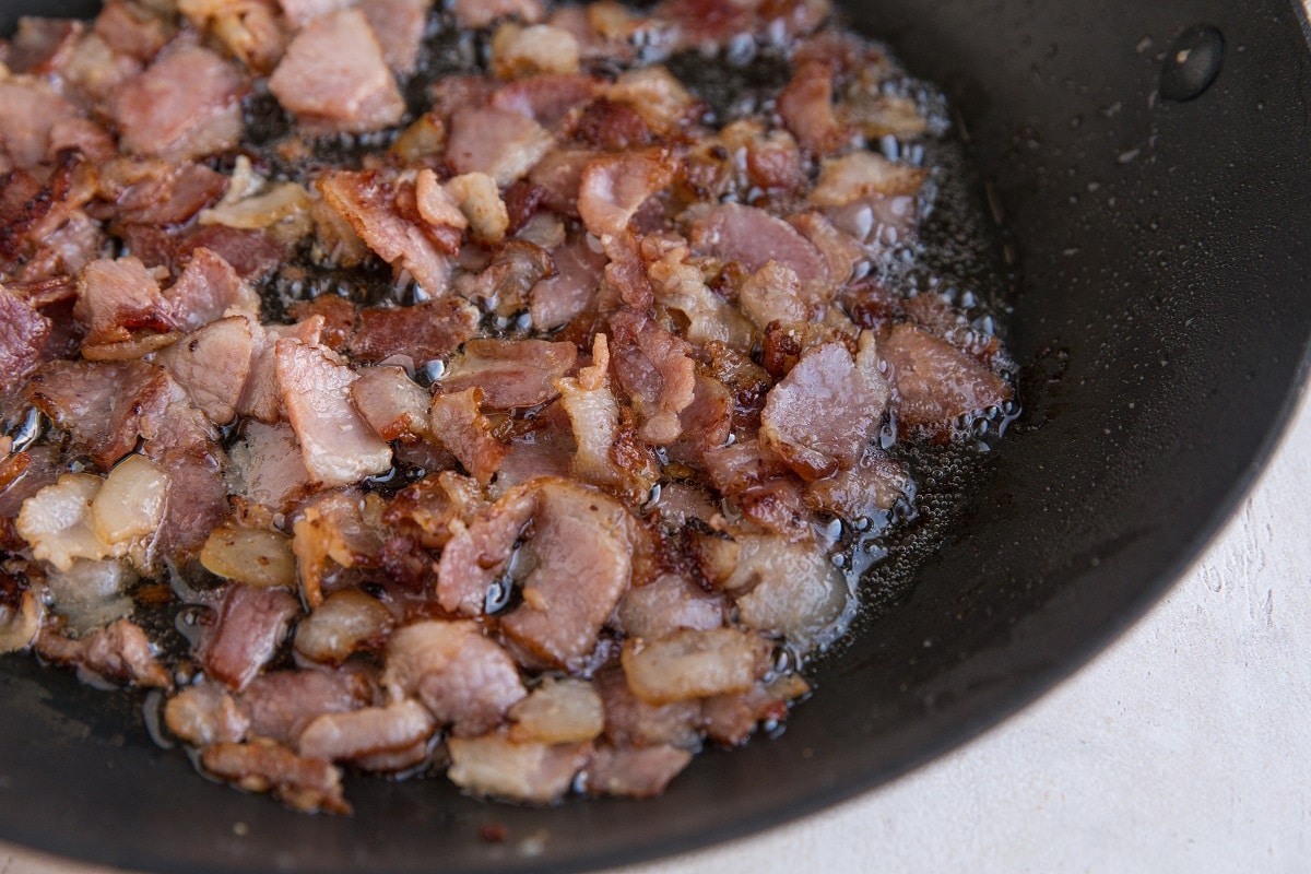 Chopped bacon cooking in a skillet