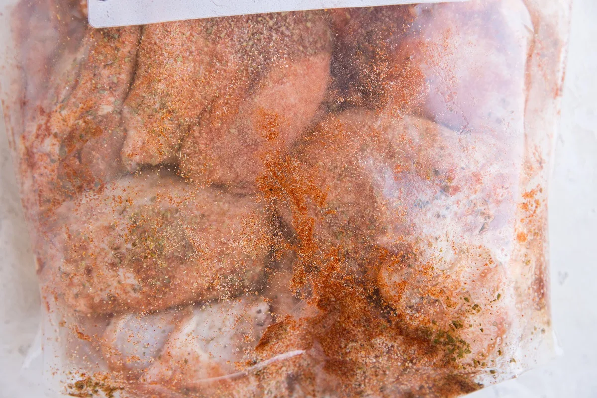 Bag of raw chicken with seasonings to be marinated in the refrigerator