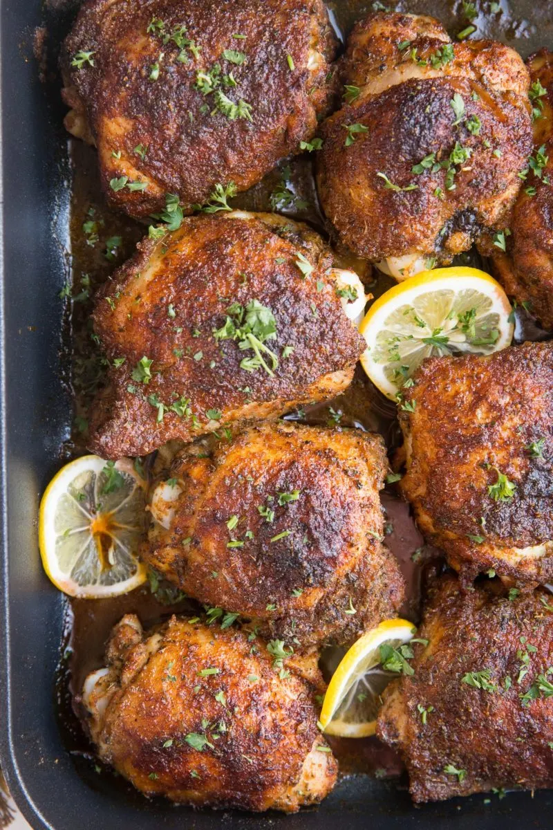 top down photo of blackened chicken thighs in a casserole dish